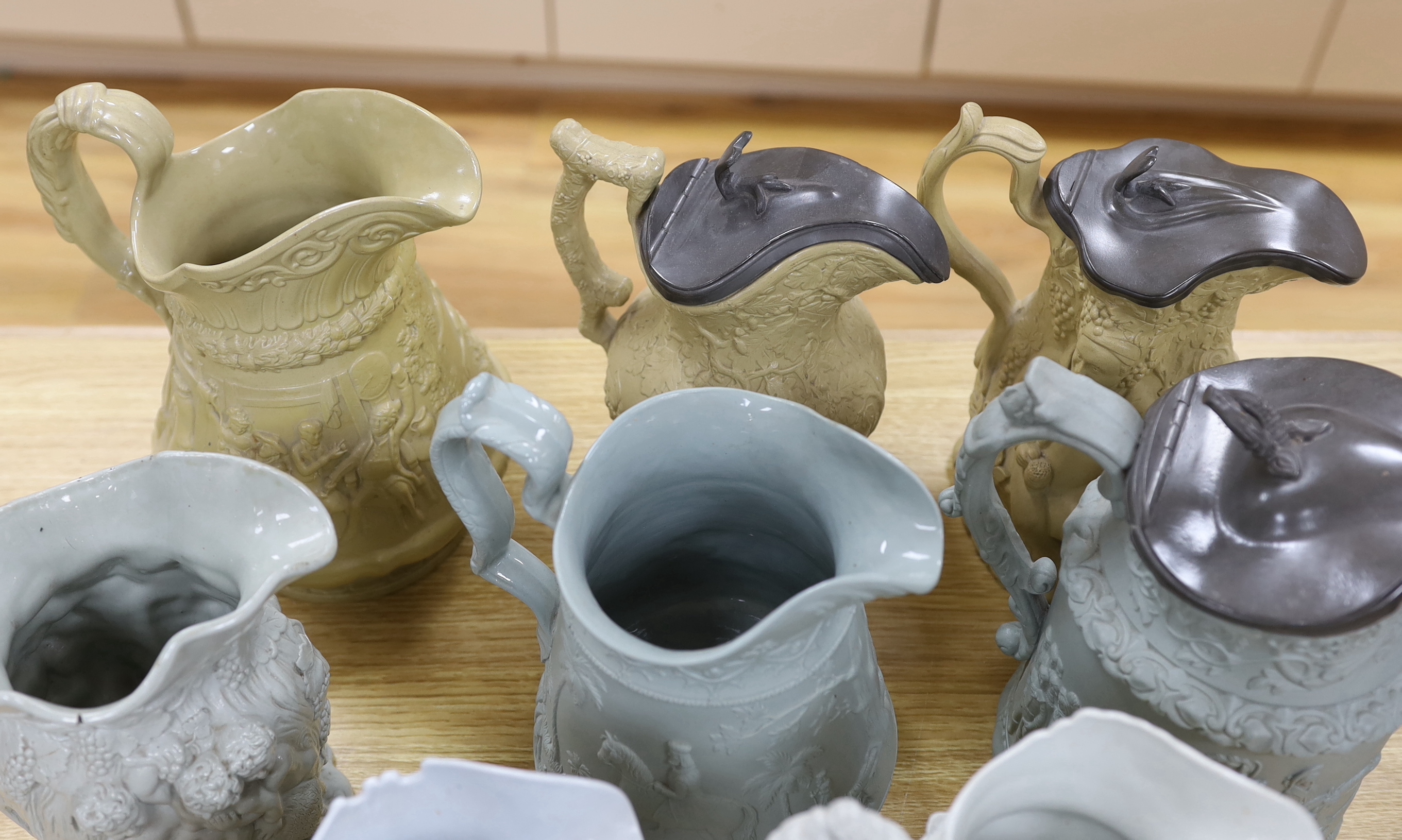 A collection of Victorian Charles Meigh and TJ & JM Mayers stoneware jugs, including Gothic relief designs, some with pewter lids, the largest 23cm high